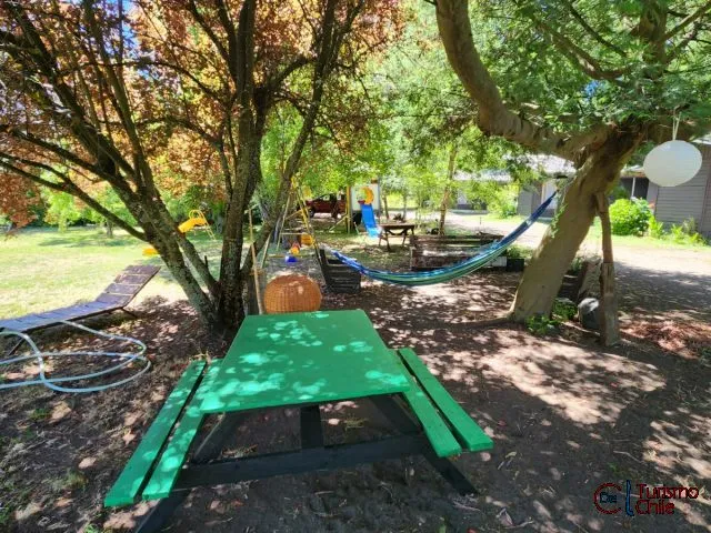 Área de juegos con mesa de picnic, hamaca y parque infantil