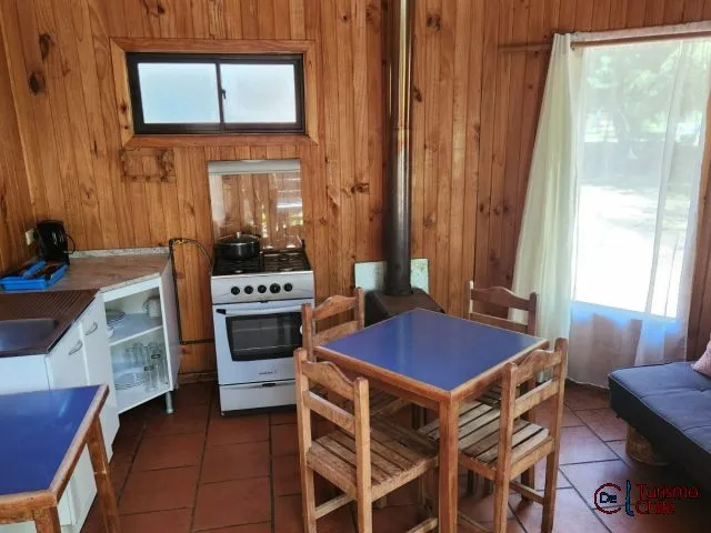 Cocina equipada con cocina a gas, muebles de madera y comedor