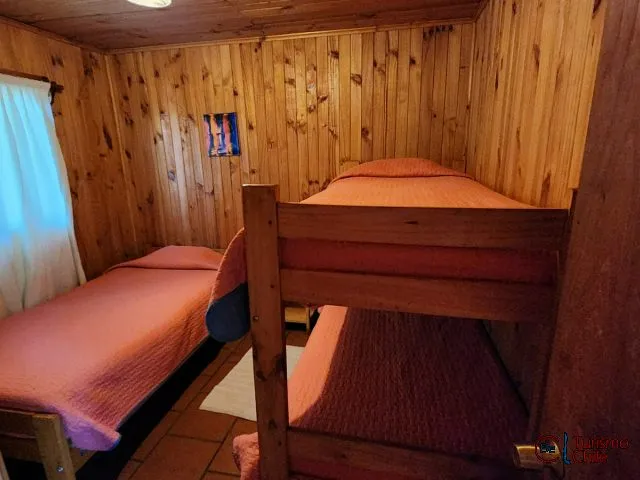 Dormitorio con literas de madera en cabaña Cuatro Cascadas
